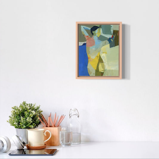Framed abstract painting on a white wall with desk items below