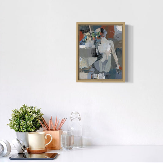 Framed artwork on a white wall above a desk with office supplies.