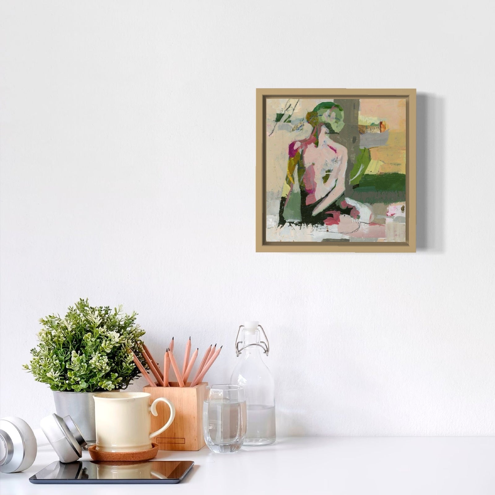 Framed artwork on a white wall with decorative items below