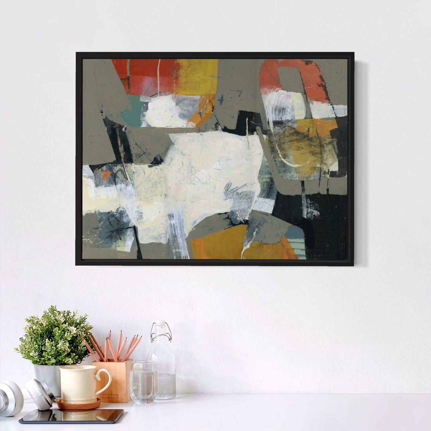 Abstract painting on a wall with a desk and decor items below