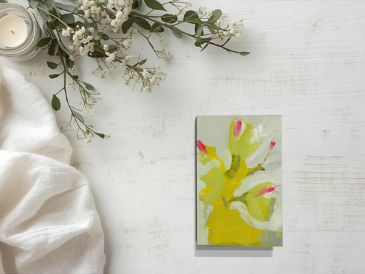 Artistic card with floral design on a white surface with flowers and a candle.