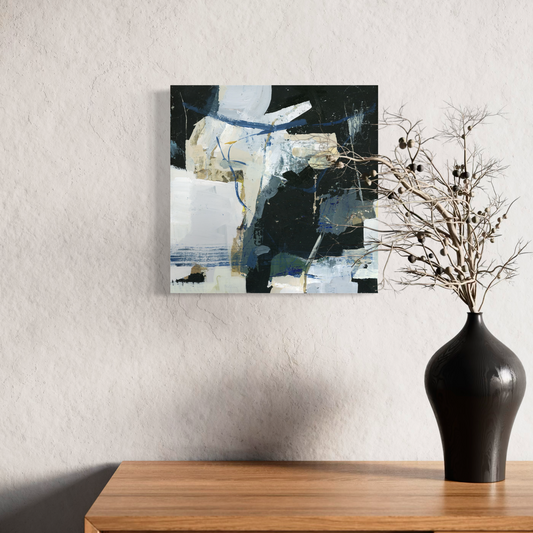 Abstract painting on a wall above a wooden console table with a black vase containing dried branches.