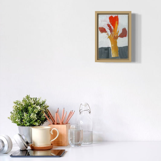 Framed artwork on a white wall with decorative items below